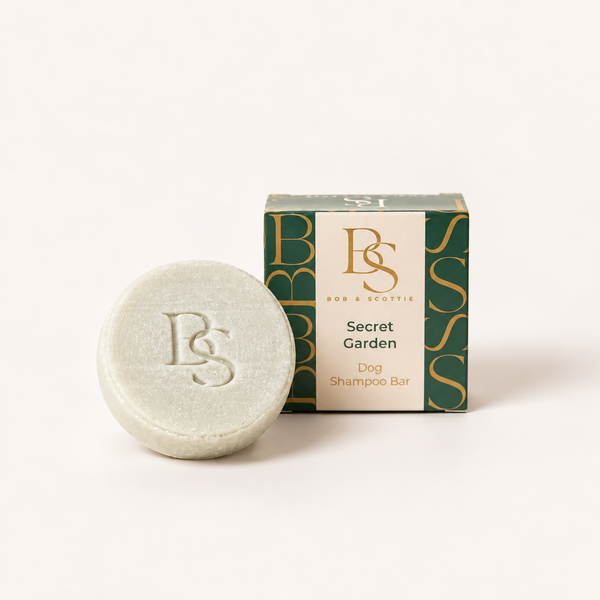 Secret Garden hondenshampoo bar in crème naast de groene verpakking van Bob & Scottie