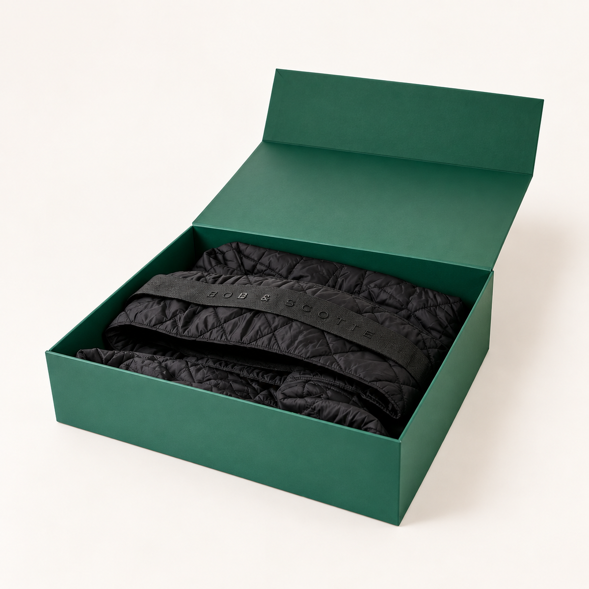 Geopende groene geschenkdoos met The Bob Carrier in zwart erin