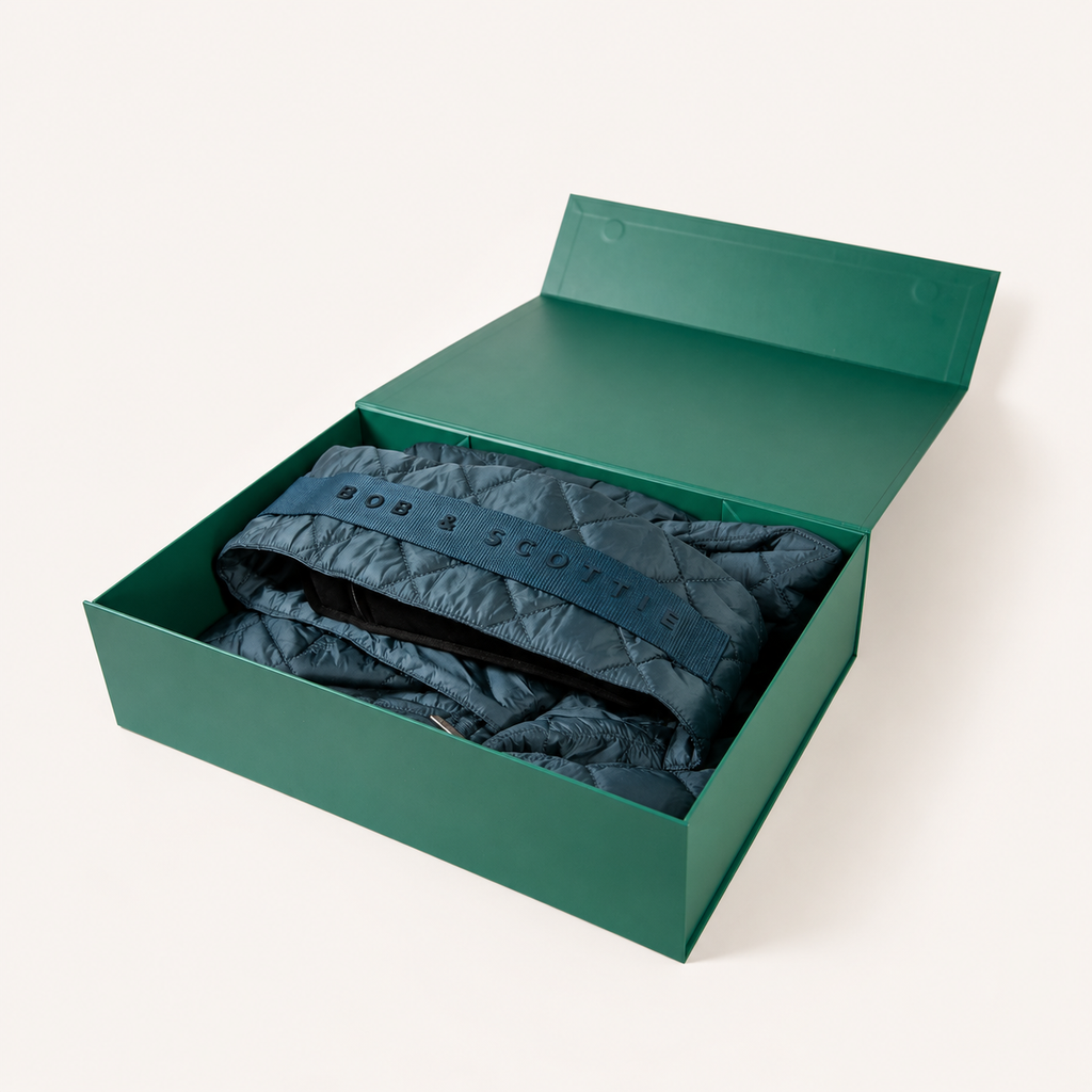 Geopende groene geschenkdoos met The Bob Carrier in petrol erin